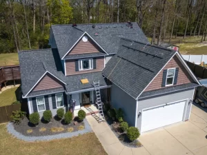 Two-story suburban home with roof repair equipment and a ladder. -exterior home remodel