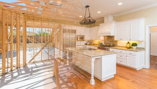 A kitchen under construction, blending finished cabinets and granite countertops with exposed framing. -home improvement services